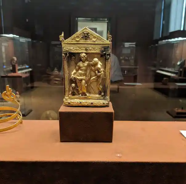 Gold naiskos with relief of drunken Dionysos and Satyr decorated with garnets and emeralds